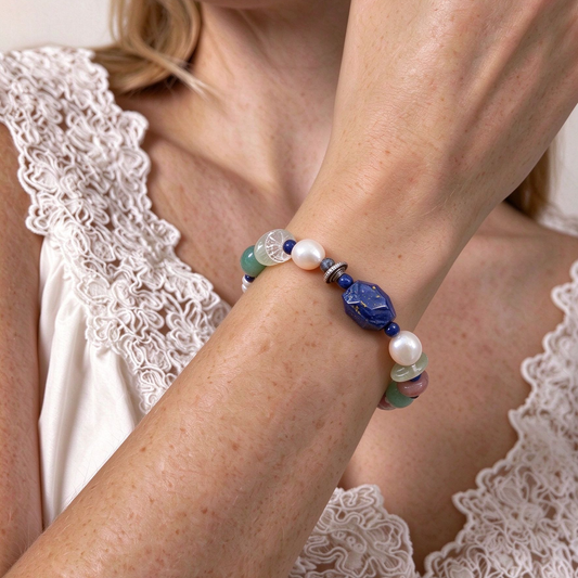 Model wearing colorful multi-gemstone beaded bracelet stacked with linen clothing in soft natural light