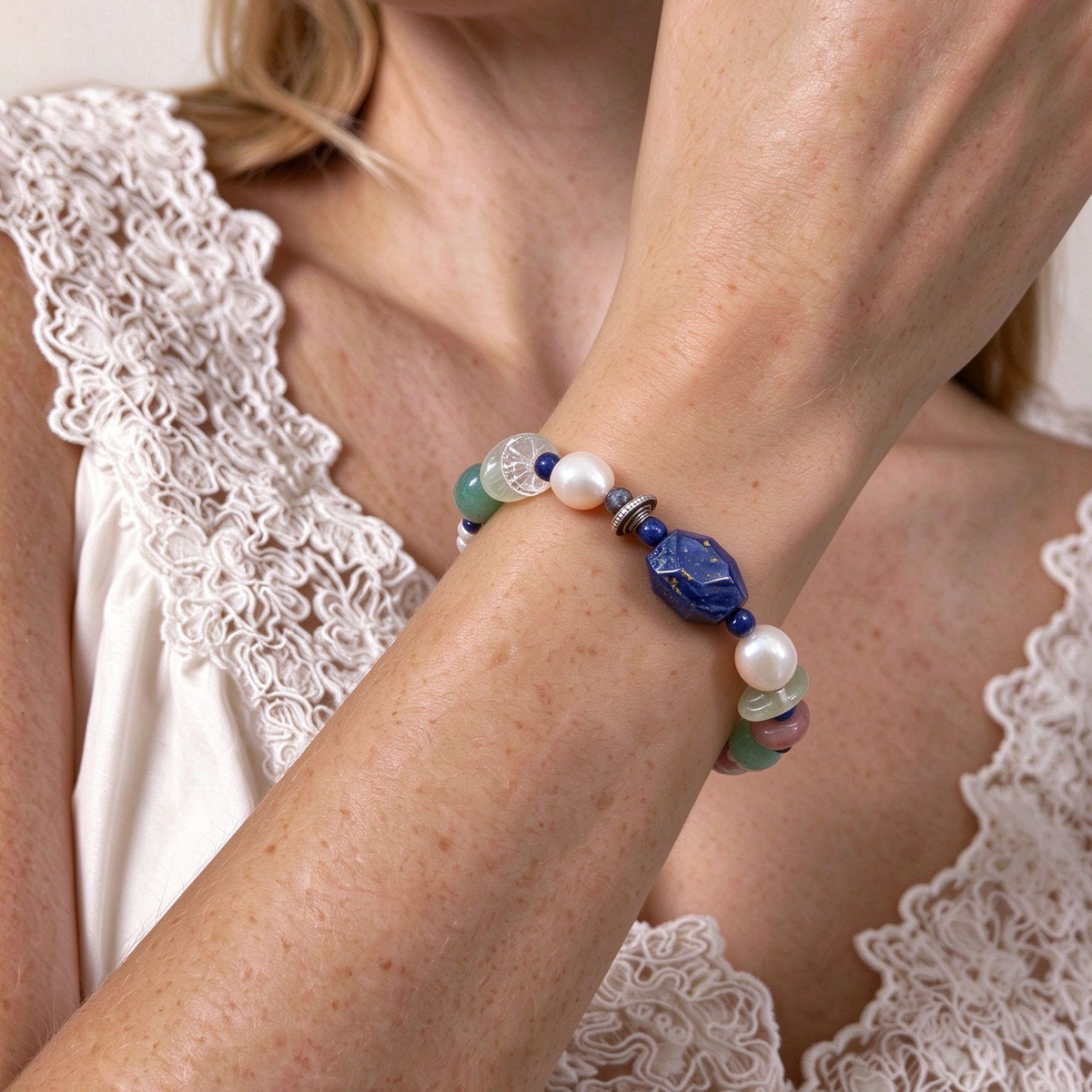 Model wearing colorful multi-gemstone beaded bracelet stacked with linen clothing in soft natural light