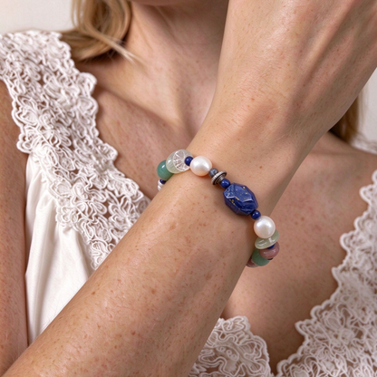 Model wearing colorful multi-gemstone beaded bracelet stacked with linen clothing in soft natural light