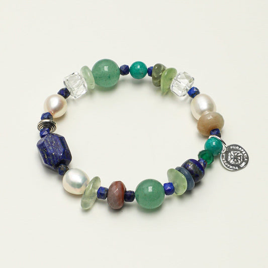 Handcrafted multi-gemstone beaded bracelet with lapis lazuli, pearls, and S925 silver coin charm on plain background