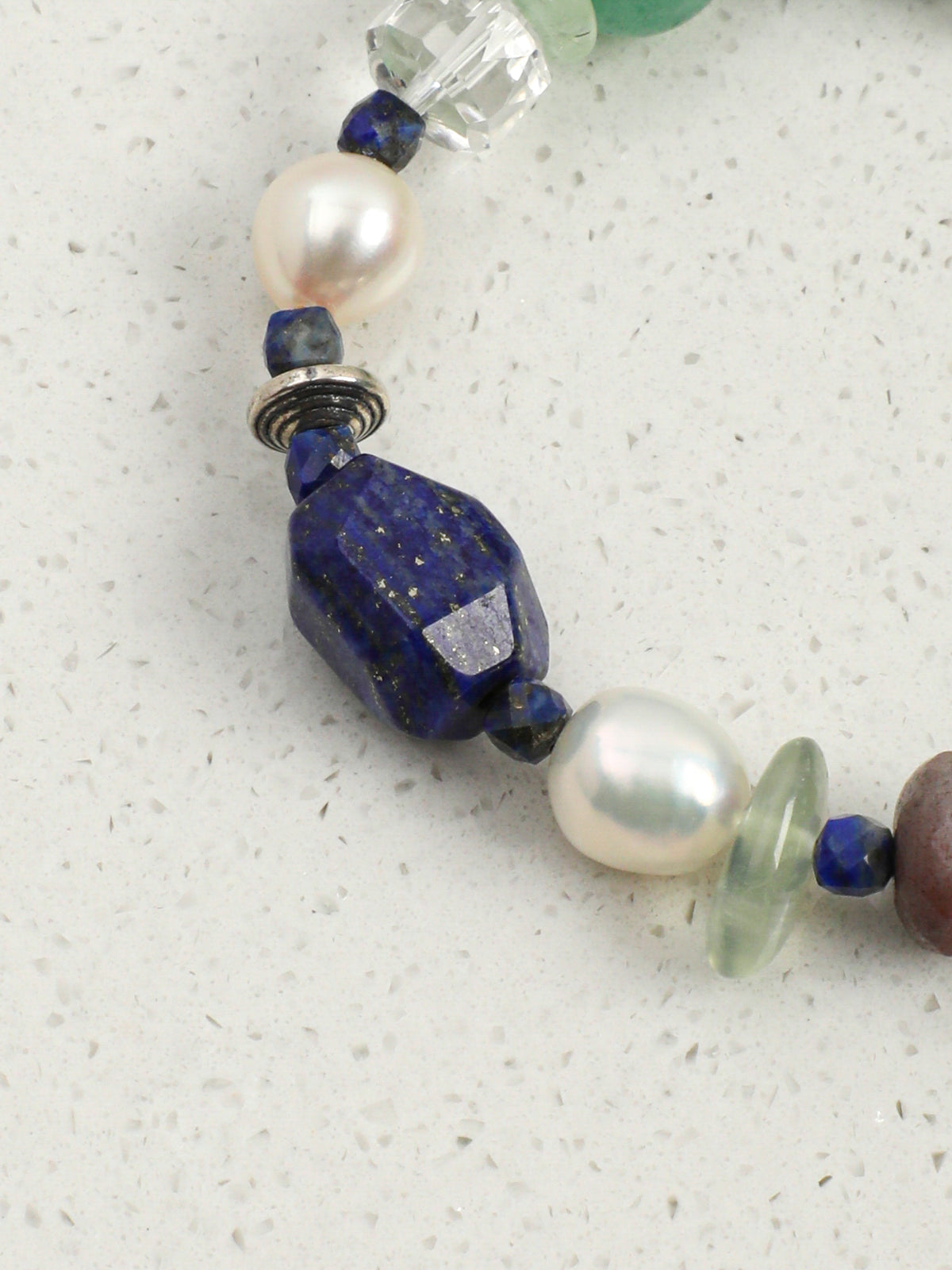 Close-up shot of rich blue lapis lazuli and vibrant green aventurine beads on gemstone bracelet