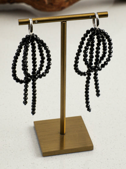 Detailed view of handcrafted dark coquette ribbon bow and beaded tassels