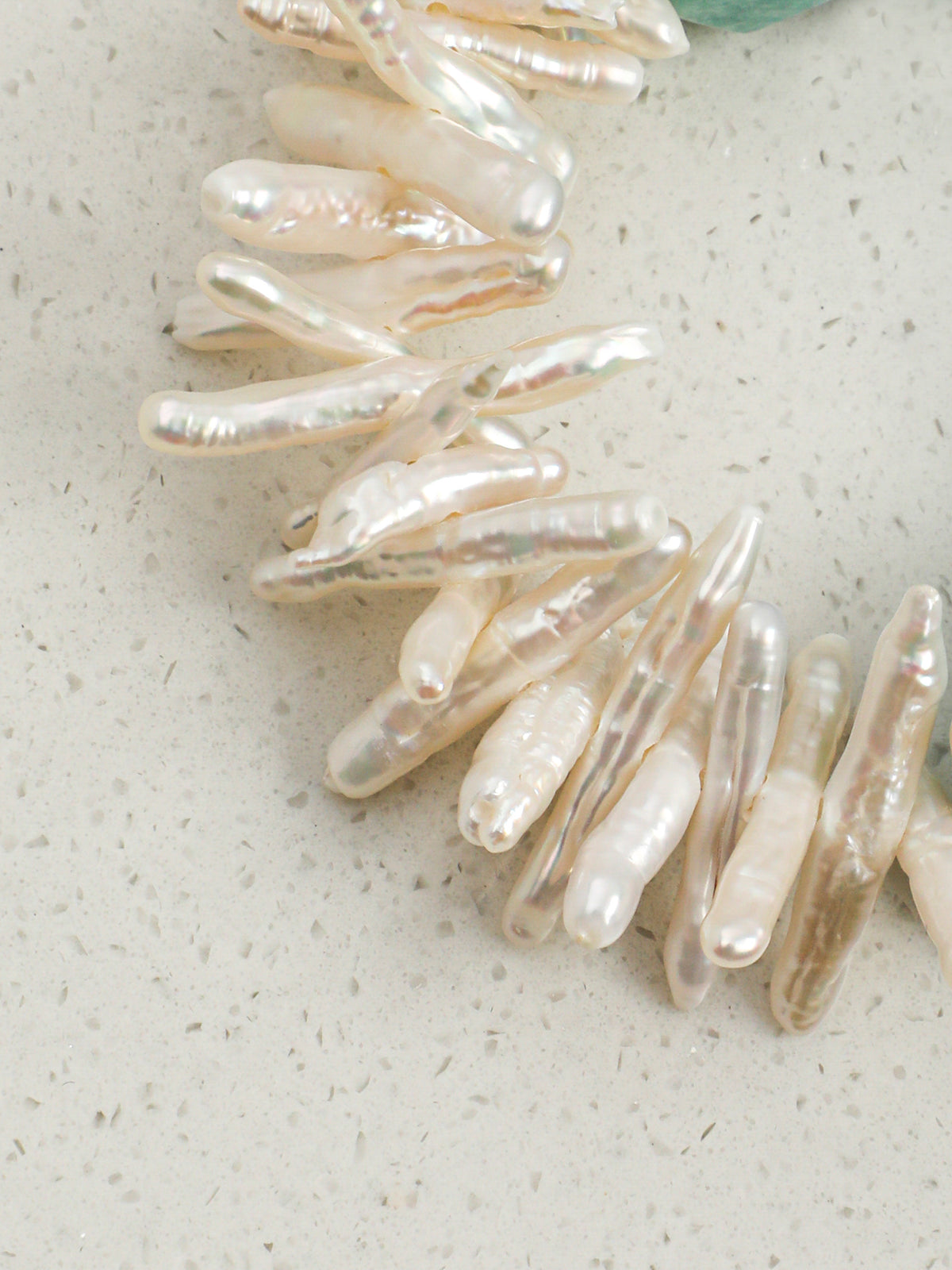 Detail of densely clustered natural white baroque needle pearls with middle-drill technique