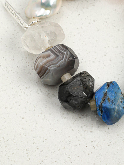 Close-up shot of raw deep blue lapis lazuli, apatite, and teal amazonite freeform beads