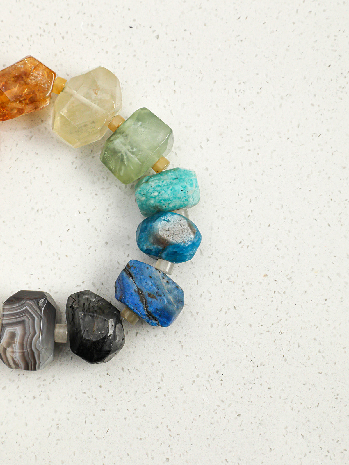Close-up shot of raw deep blue lapis lazuli, apatite, and teal amazonite freeform beads