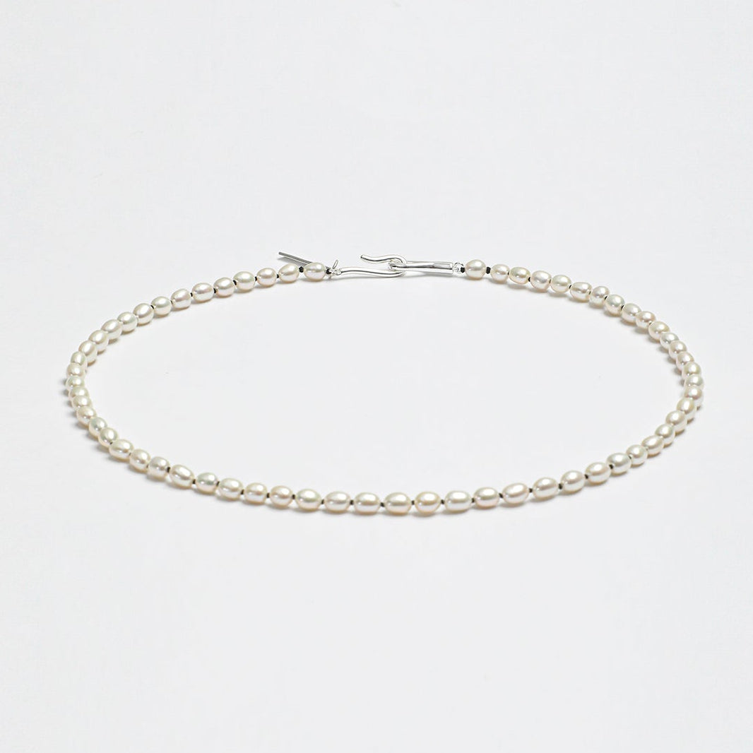 Minimalist LINJORA handcrafted choker necklace featuring a delicate single strand of genuine natural seed pearls on a clean white background.