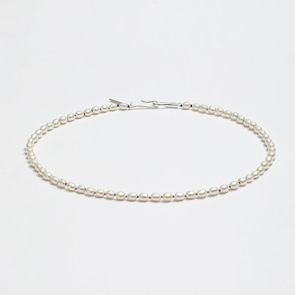 Minimalist LINJORA handcrafted choker necklace featuring a delicate single strand of genuine natural seed pearls on a clean white background.