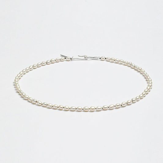Minimalist LINJORA handcrafted choker necklace featuring a delicate single strand of genuine natural seed pearls on a clean white background.